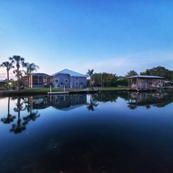 Haus am Wasser mit Palmen