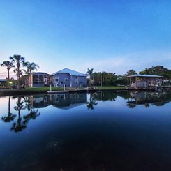 Haus am Wasser mit Palmen